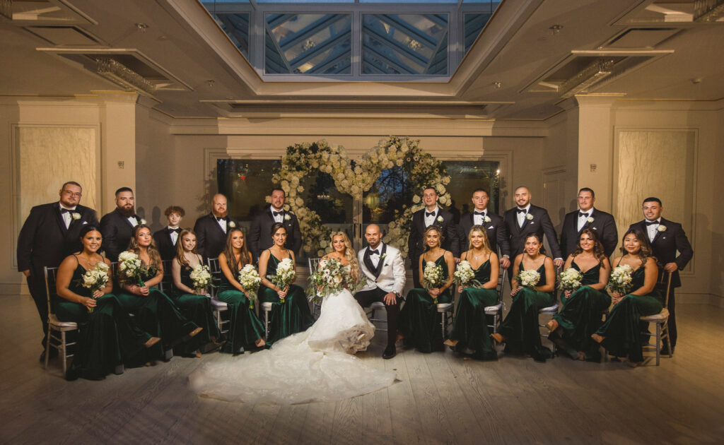 Wedding party posed together with the bride and groom