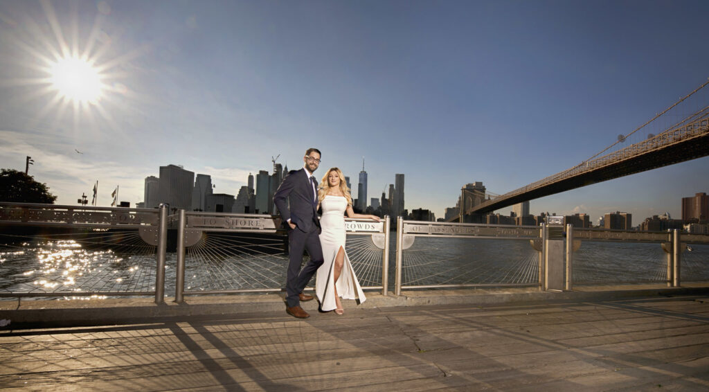 Bride and groom on a waterfront terrace with the city skyline behind them