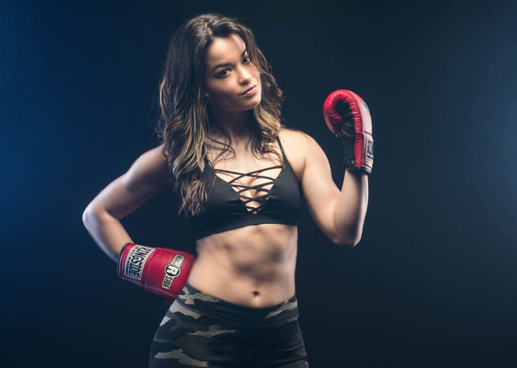 Woman in boxing gloves posed in dramatic studio light